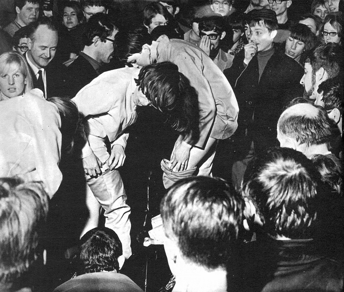 Iris de Leeuw and Ina van der Zwan swap trouser legs during the Great Pop Show. Page from Voorwaarts. Maandblad van de Socialistische Jeugd, vol 4, 1967.